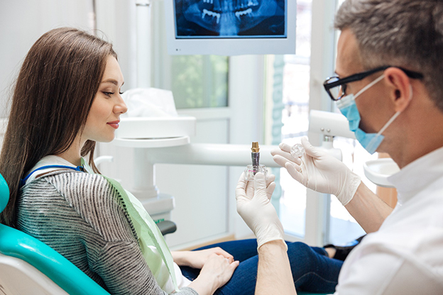 A dentist explaining the cost of dental implants in Garland